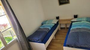 2 Einzelbetten in einem Zimmer mit Fenster in der Unterkunft lodge sibylle in Soubey