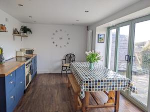 a kitchen with a table and a clock on the wall at Millmoor Cottage - Broad Haven in Broad Haven