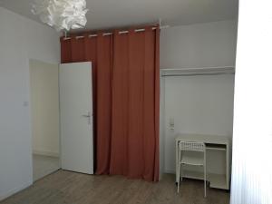 une chambre avec un rideau rouge et une table dans l'établissement La Petite Maison, à Rezé