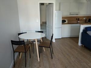 La Petite Maison في ريزي: وجود مطبخ وطاولة وكراسي في الغرفة
