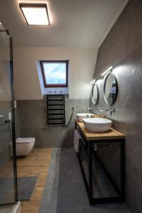 a bathroom with two sinks and a toilet and a window at Apartamenty Na Szlaku in Iwonicz-Zdrój