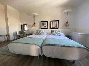 a bedroom with a large bed with two pillows at Torre del Postigo By KubiK in Cáceres