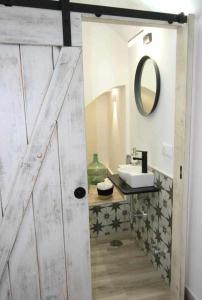 a bathroom with a wooden door and a sink at Torre del Postigo By KubiK in Cáceres +12 photos