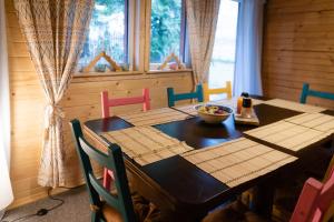 a dining room with a wooden table and chairs at Korbielówka in Korbielów