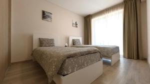 una camera da letto con due letti e una finestra di Elite Residence 2C a Portimão Altre 36 foto