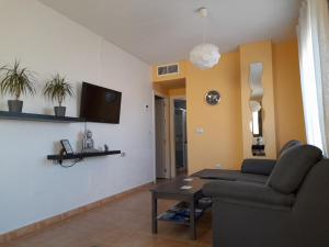 ein Wohnzimmer mit einem Sofa und einem Tisch in der Unterkunft Apartamento Relax in Águilas