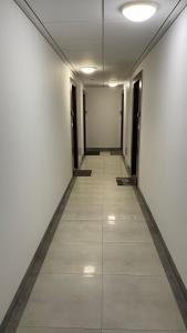 a long hallway with white walls and a tile floor at Apartament nad jeziorem , ZEFIR in Augustów
