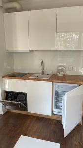 a kitchen with white cabinets and a sink at Apartament nad jeziorem , ZEFIR in Augustów