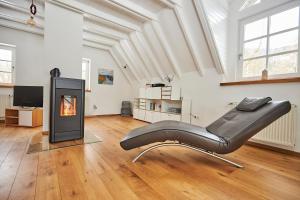 a leather chair in a room with a fireplace at Komfortables Ferienhaus - Traumhafte Entspannung in purer Natur in Gellershausen