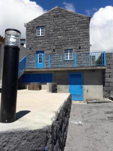 una casa con puertas azules y un poste negro en Casa da Pedra, en Horta