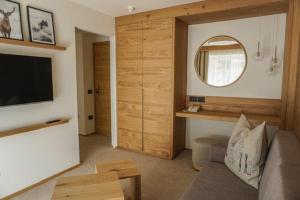 a living room with a couch and a flat screen tv at Garni Schenk in Selva di Val Gardena