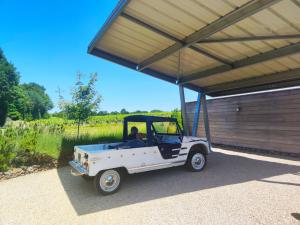 a white golf cart parked under a garage at La Demeure de Saint Fiacre in Saint-Fiacre-sur-Maine +33 photos