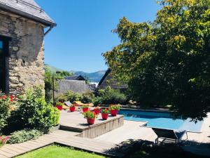 a garden with a swimming pool and some plants at Maison Eth Bordac & Bordac Petit in Cazeaux-de-Larboust
