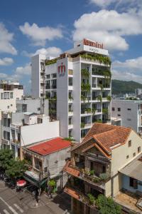 wysoki biały budynek z budynkiem z roślinami w obiekcie Le Mint Hotel Quy Nhơn w mieście Quy Nhơn