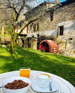 una mesa con un tazón de comida y una taza de café en Mulino del Lentino, en Nibbiano