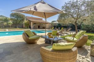 une terrasse avec des chaises et un parasol ainsi qu'une piscine dans l'établissement La Rose Des Vents, à Modène