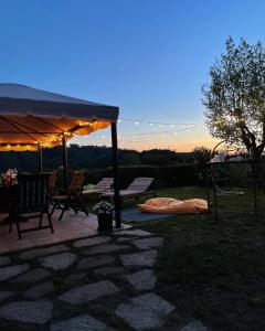 patio ze stołem i krzesłami pod namiotem w obiekcie B&B Codivilla w mieście Sasso Marconi