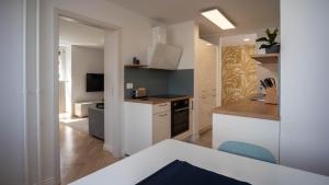 uma cozinha com armários brancos e uma cadeira azul em Sunnyside Apartment in the City Center em Ljubljana