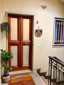 una porta in legno in un edificio con una pianta in vaso di Maison Matisse a Siracusa