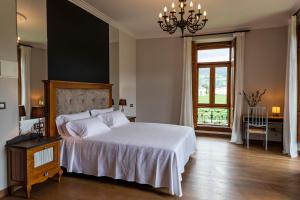 a bedroom with a large white bed and a window at POSADA SEMILLA in La Abadilla