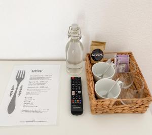 a basket with a bottle of water and a remote control at Lake View Homestay with Private Room and Bathroom in Châtillon