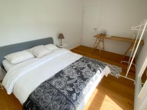 a bedroom with a bed with a black and white blanket at Lake View Homestay with Private Room and Bathroom in Châtillon