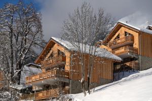 un gran edificio de madera en la nieve en Le Refuge des Sens chalet Quiétude en Vaujany