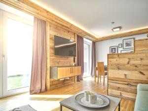a living room with a wooden wall with a television at The Spa Suite Top 3- Tauplitz Residences by AAHH in Tauplitz