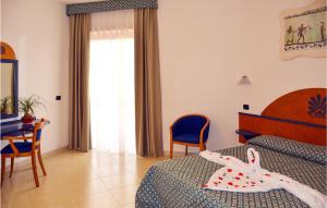 Cette chambre d'hôtel comprend deux lits, une table et des chaises. dans l'établissement Akiris Bilo, à Nova Siri Marina