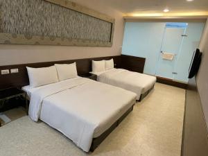 台北的住宿－苓旅萬年-LIN INN Wan Nian，酒店客房设有两张床和电视。