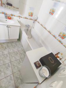 a bathroom with a sink and a toilet and a book at Maison de village - Suite Baroque cosy et élégante à 1 h de Paris proche Fontainebleau 