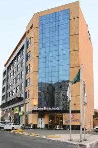 a large building with a glass facade on a street at Quiet Dreams - King Road Branch in Jeddah