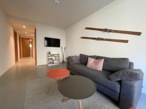 ein Wohnzimmer mit einem Sofa und einem Tisch in der Unterkunft Ferienwohnung 3,5 Zimmer direkt an Ski- und Bikepiste in Flims