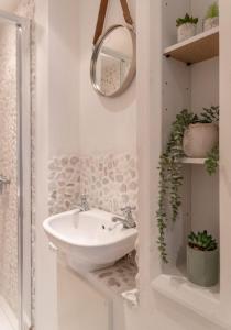a white bathroom with a sink and a mirror at Beach House in Cromer