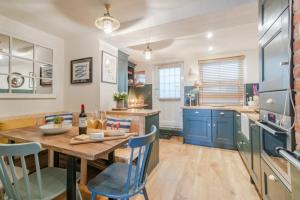 a kitchen with a wooden table and blue cabinets at Beach House in Cromer