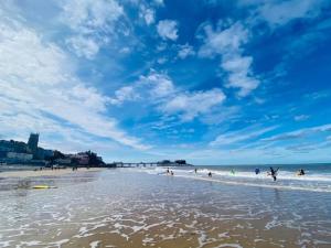 クローマーにあるBeach Houseのビーチで水遊びをしている人々のグループ