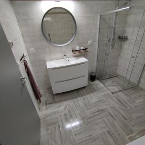 a bathroom with a sink and a shower and a mirror at Ubytování Valentovi in Veľký Meder +13 photos