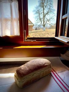 a loaf of bread sitting in front of a window at Pensiunea Agroturistica Casa Pribegilor in Breb