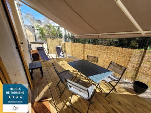 un patio con mesa y sillas en una terraza en L'Azimut de Châtel-Guyon, en Châtel-Guyon