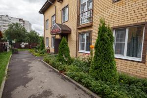 una casa con árboles de hoja perenne delante de ella en Hotel Teremok Proletarsky, en Tver