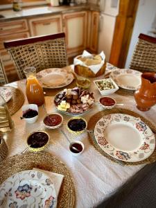 una mesa con platos y tazones de comida. en Pensiunea Agroturistica Casa Pribegilor en Breb