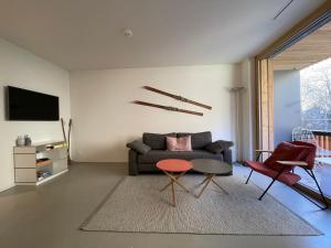 ein Wohnzimmer mit einem Sofa, einem Tisch und Stühlen in der Unterkunft Ferienwohnung 3,5 Zimmer direkt an Ski- und Bikepiste in Flims