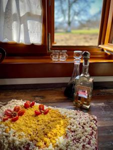 a table with a bottle of alcohol next to a window at Pensiunea Agroturistica Casa Pribegilor in Breb