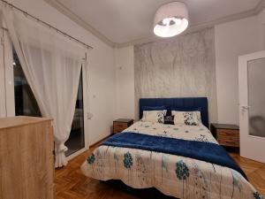 een slaapkamer met een blauw bed en een groot raam bij Arman Group Arya in Athene