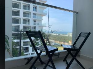 two chairs on a balcony with a view of a building at Win Condotel Apec Phú Yên in Tuy Hoa