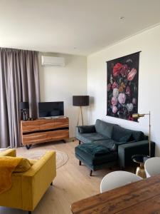 ein Wohnzimmer mit einem Sofa und einem TV in der Unterkunft Vakantiepark Schouwenduin in Burgh Haamstede