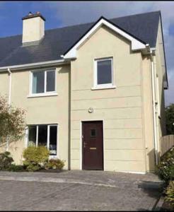 a large white house with a brown door at Townhouse Clifden: Located in the heart of Connemara in Clifden