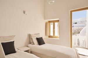 biały pokój z 2 łóżkami i oknem w obiekcie TOWN BOX w mieście Mykonos