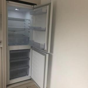 an empty refrigerator with its door open in a kitchen at Townhouse Clifden: Located in the heart of Connemara in Clifden