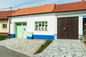 a white and blue house with a red roof at Penzion Berdina in Suchá Loz